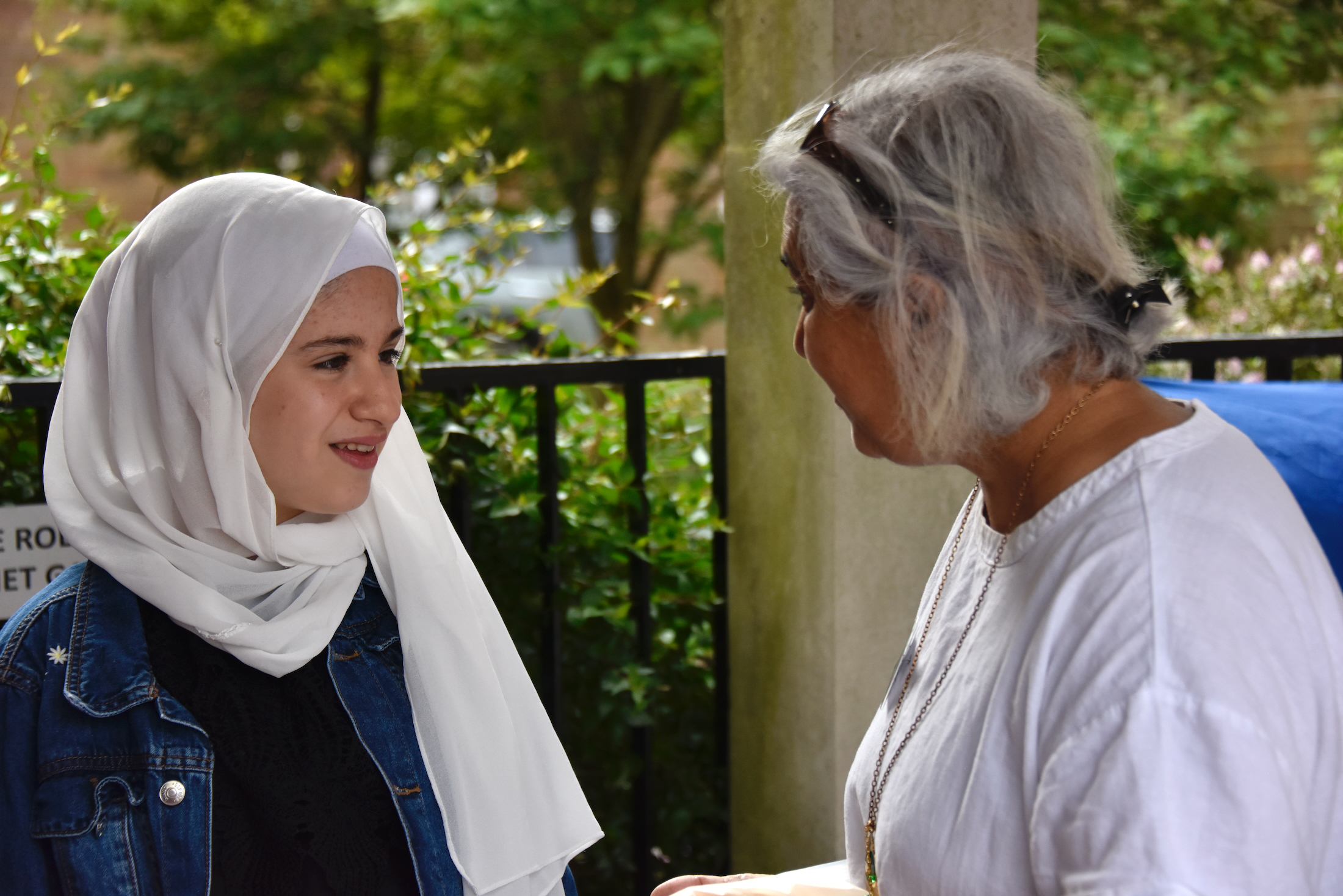 Photograph showing a girl in traditional clothing talking to a woman
